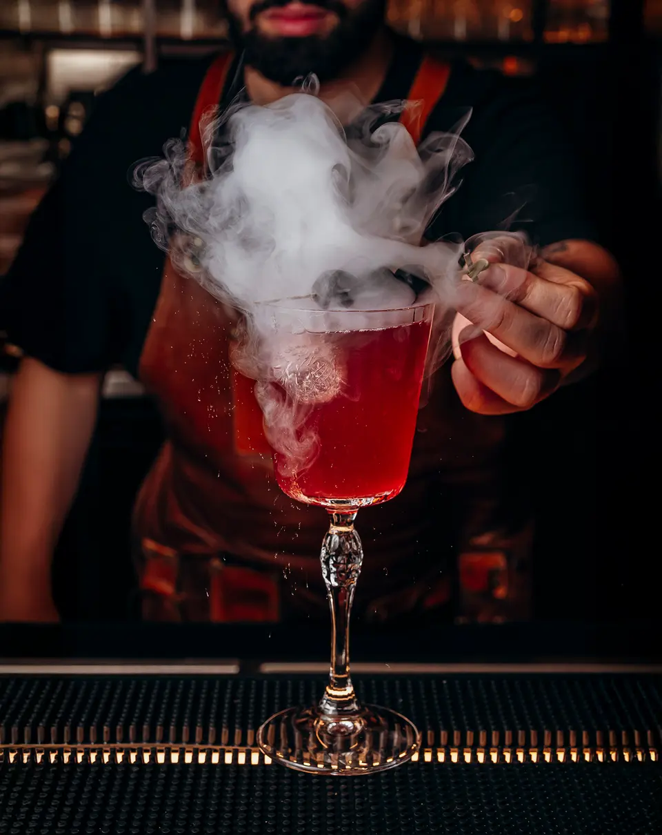 Um cocktail vermelho a fumegar ao balcão